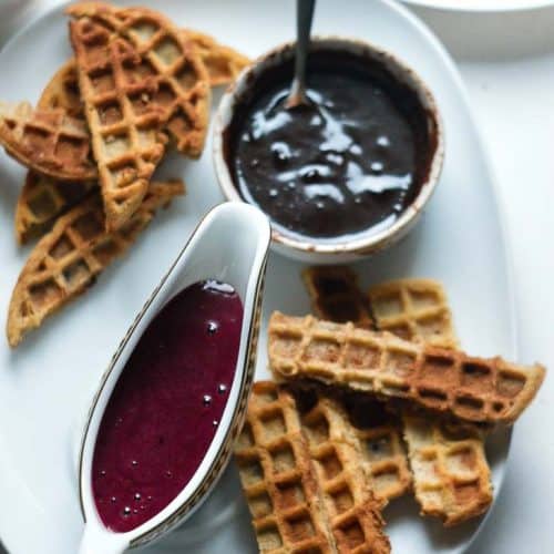 Waffle bites served with chocolate and berry sauce