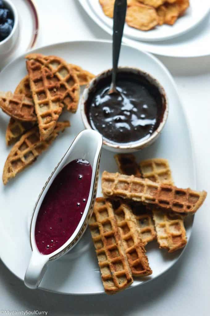 Waffle bites served with chocolate and berry sauce