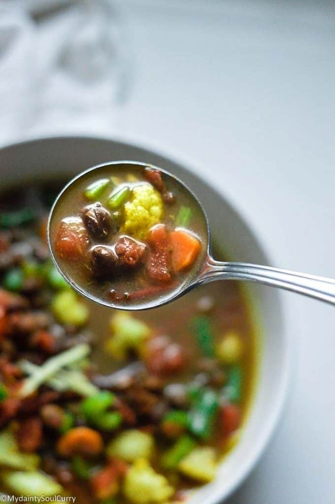 A spoonful of black chickpeas soup
