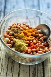 Mixing peanuts with spices and oil