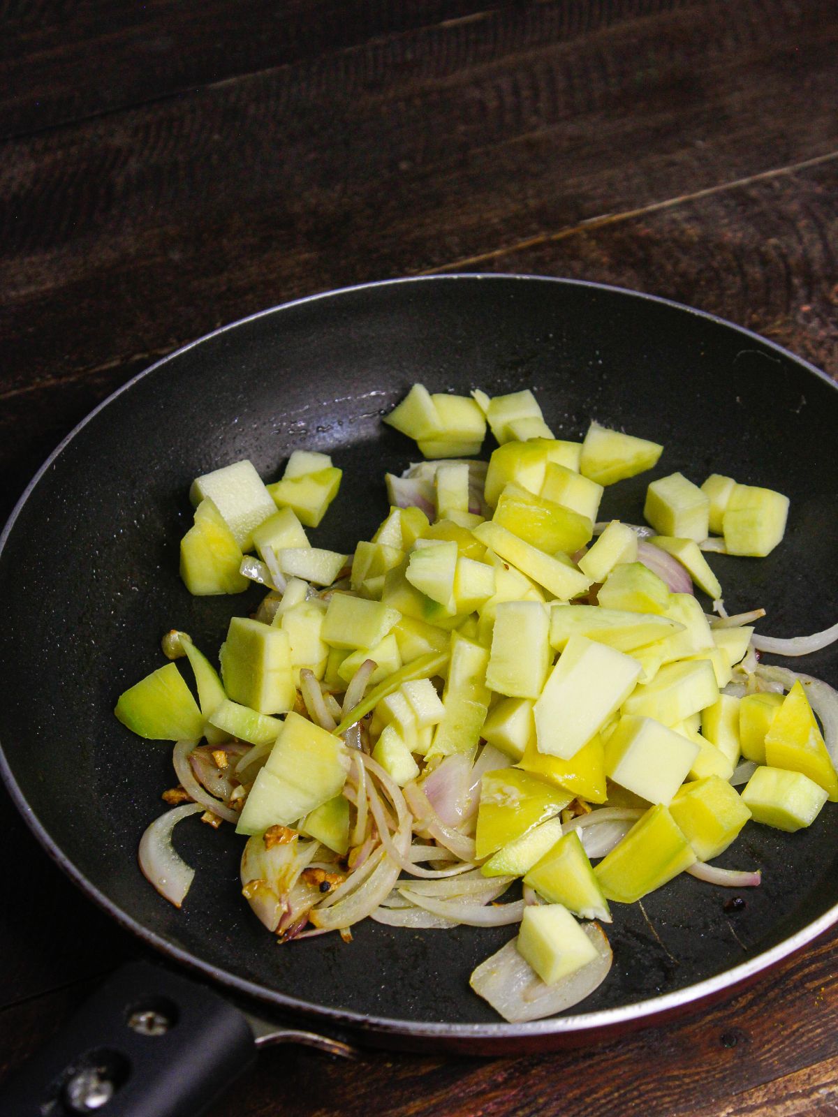 Add cubbed raw mangoes to the pan