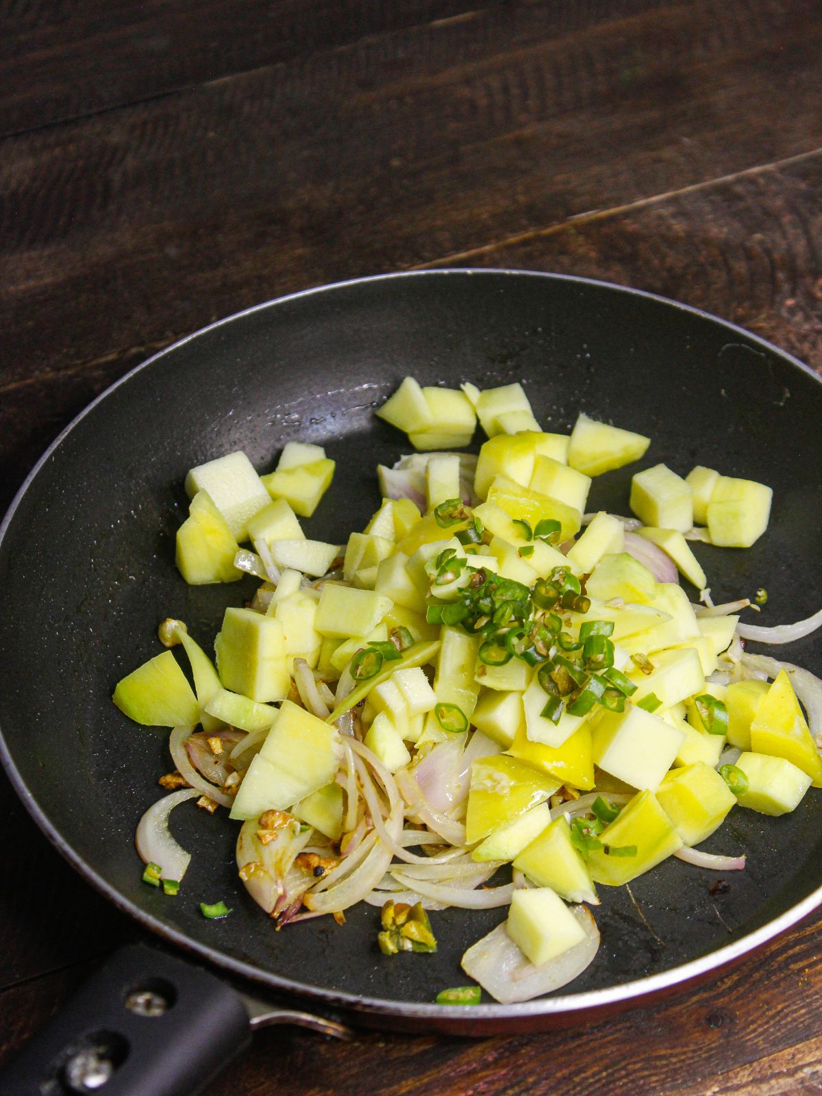 Add chopped green chilies to the pan and saute