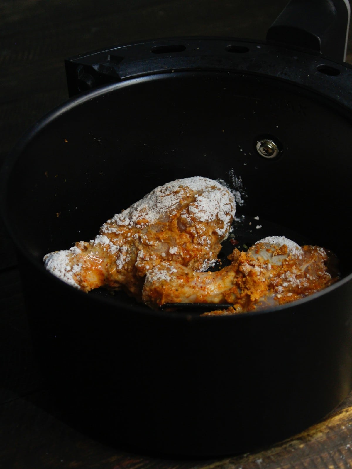 Transfer the chicken into the air fryer basket and spray some oil over it