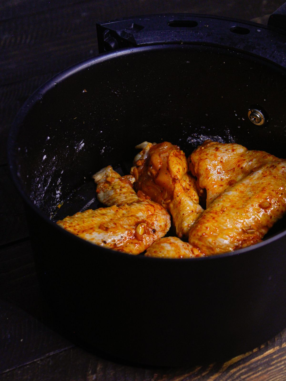 Transfer the chicken wings into the air fryer and cook it 