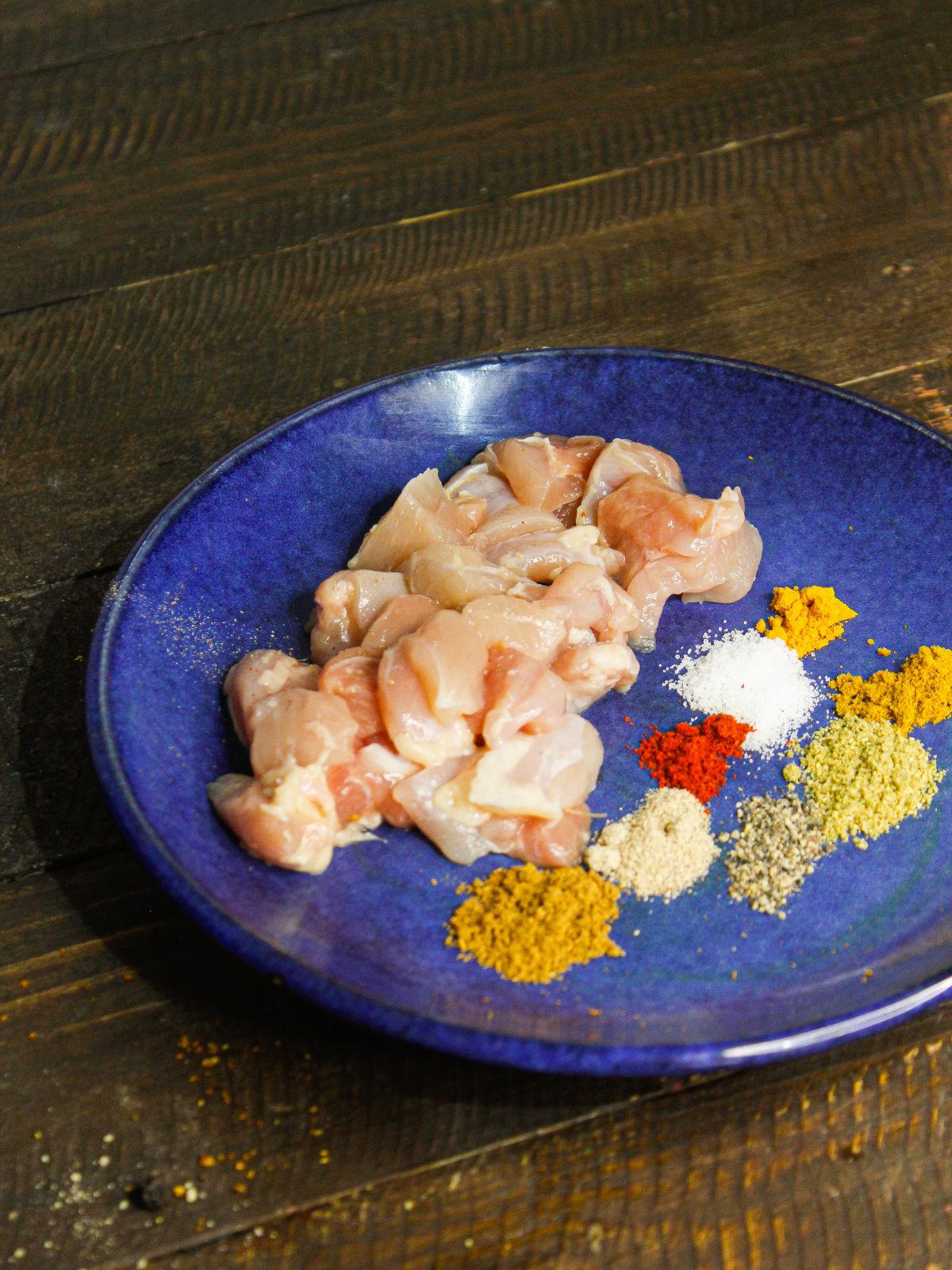 Chicken cubes along with spices in a plate