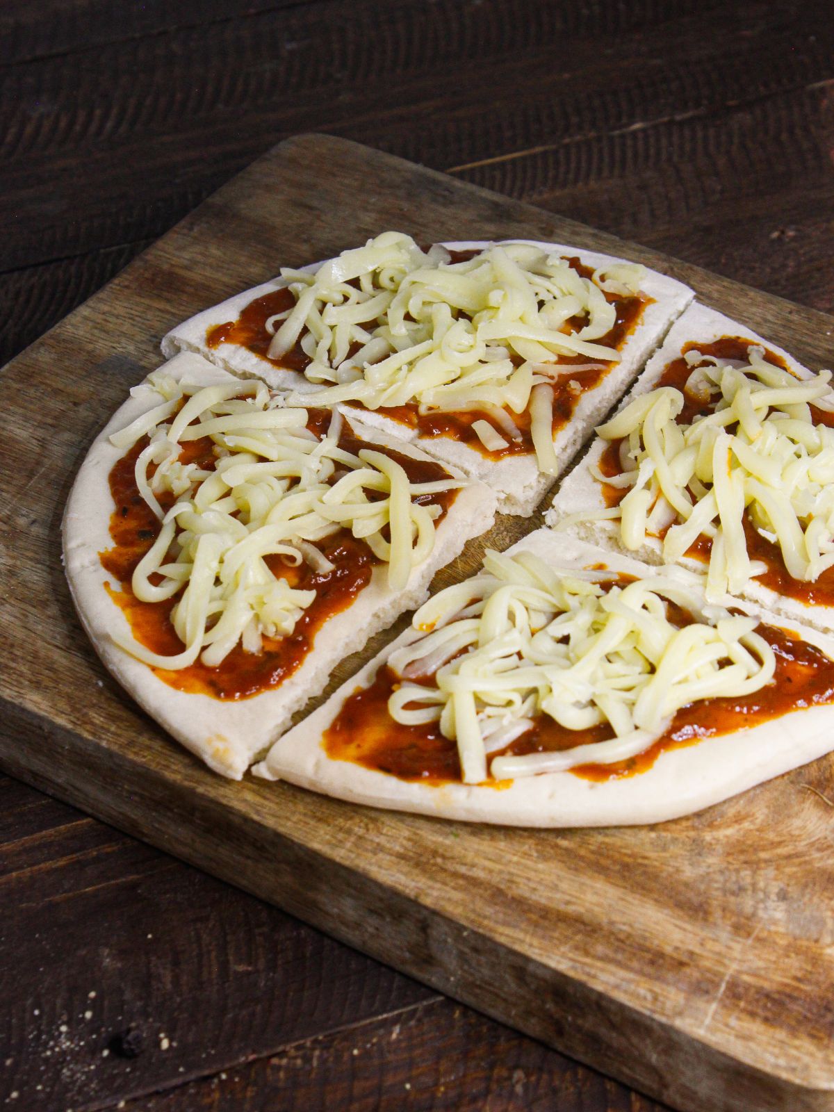 Grate mozzarella cheese over the pizza sauce layer