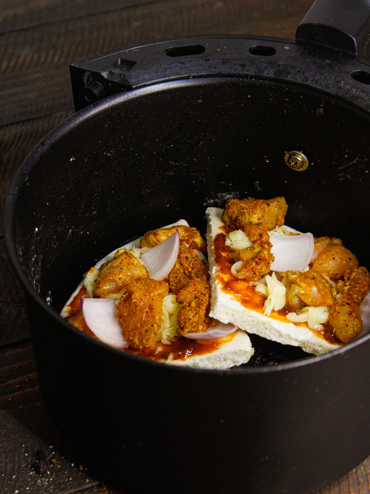 Put the pizza pieces in the air fryer basket and cook 