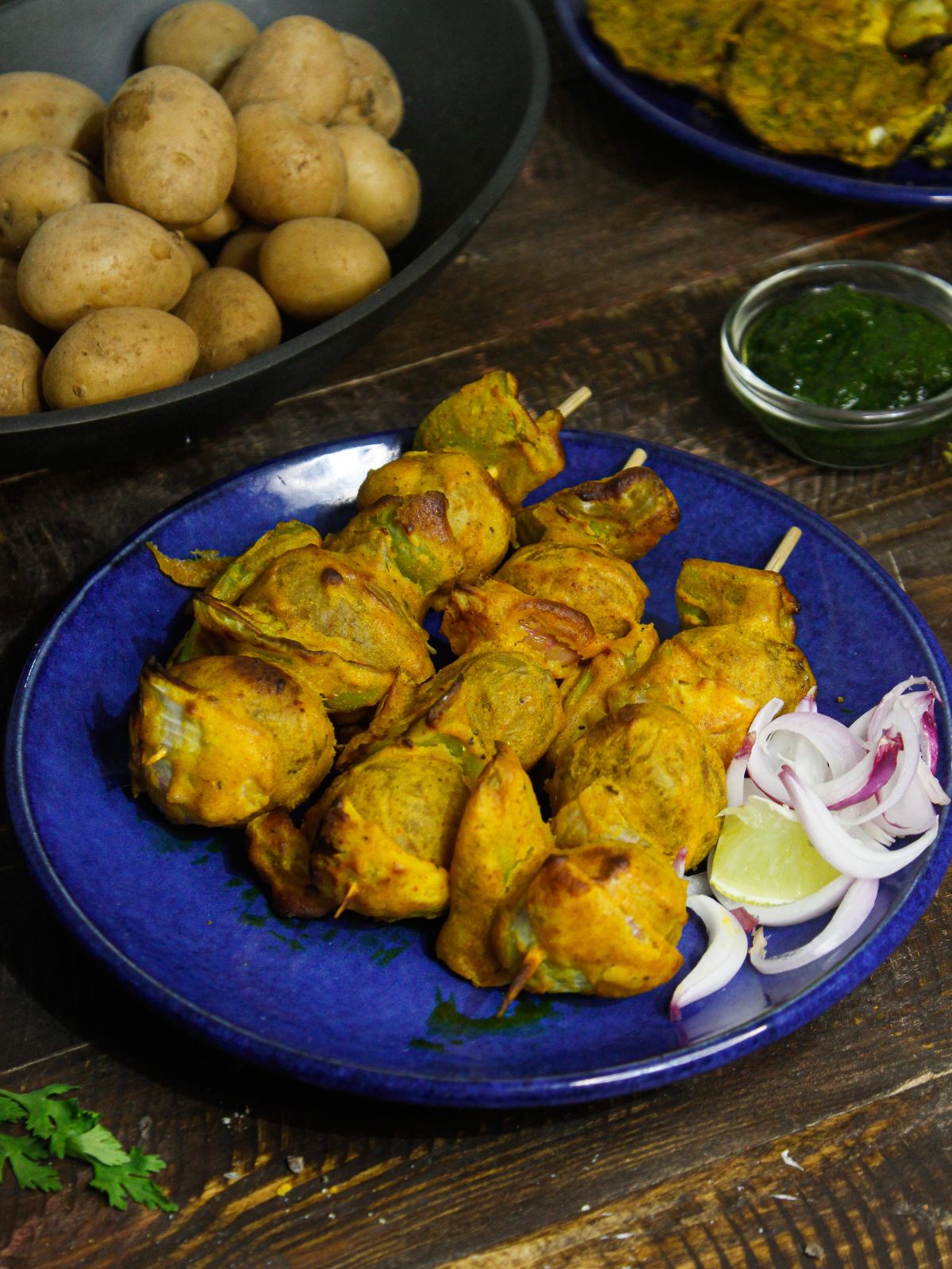 Yummy Tandoori Potatoes With Green Chutney served on a blue plate