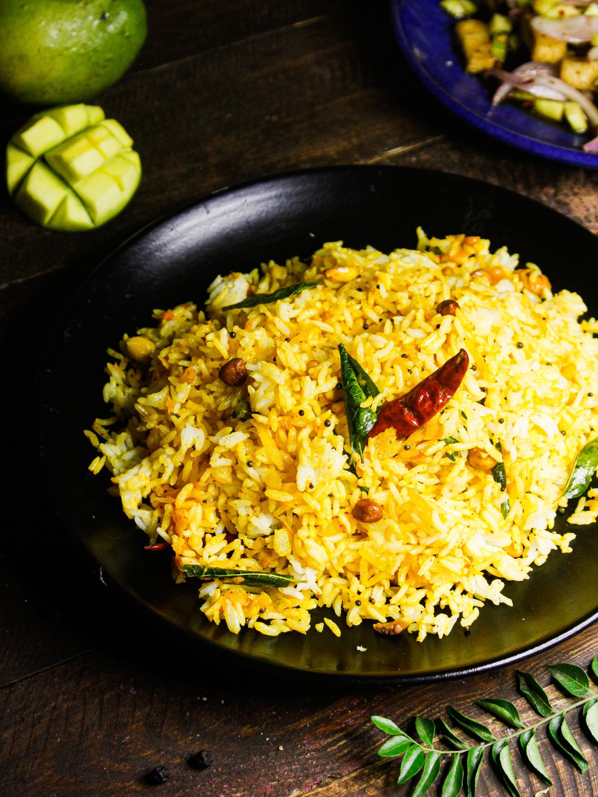 Spicy Easy Instant Pot Mango Rice served in a plate with raw mango in th background