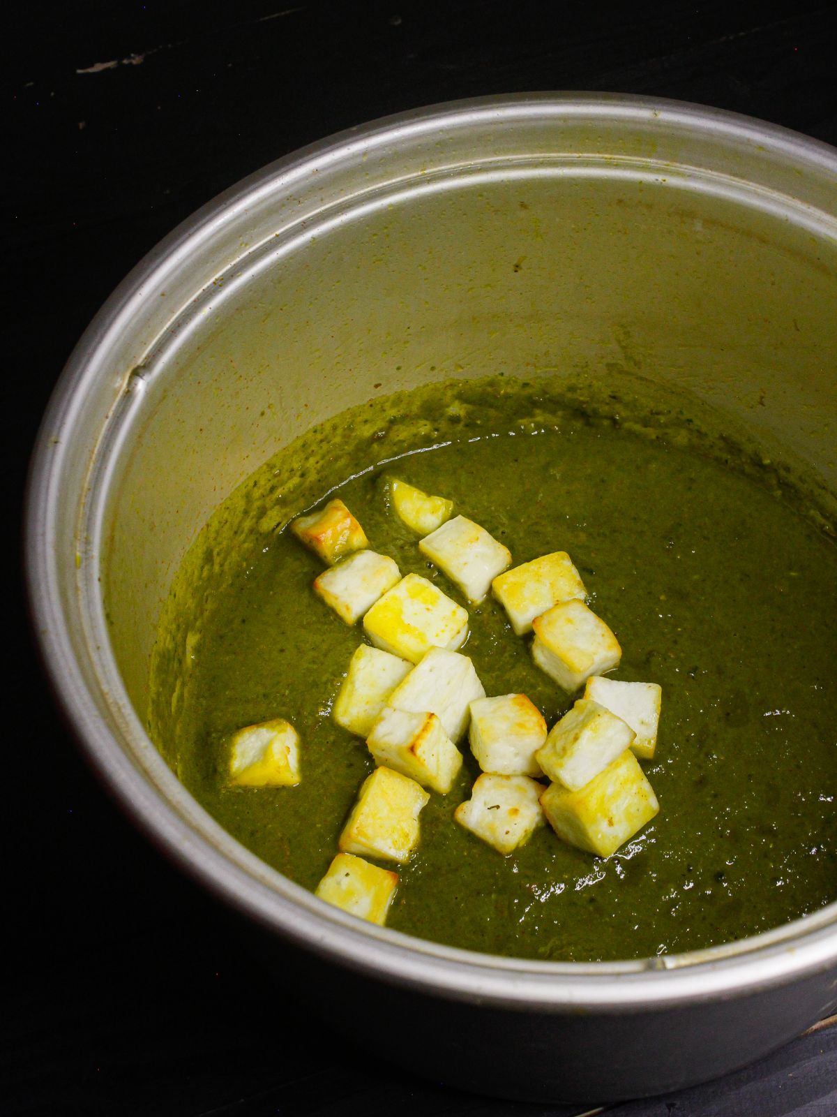 Add cooked paneer cubes to the pot and mix well