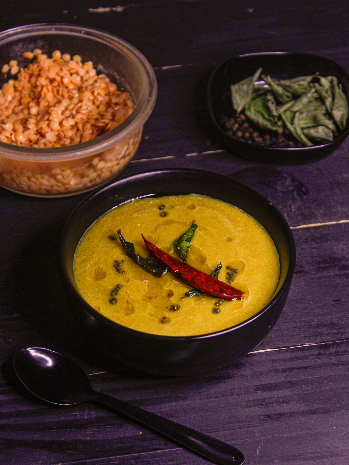 Instant Pot Red Lentil Tomato Soup served in a bowl with soaked raw red lentils in the background