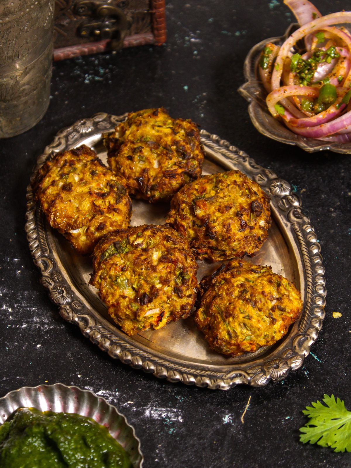 Crunchy Air Fried Chapli Kebab with Green Chutney and Salad served on a steel plate 