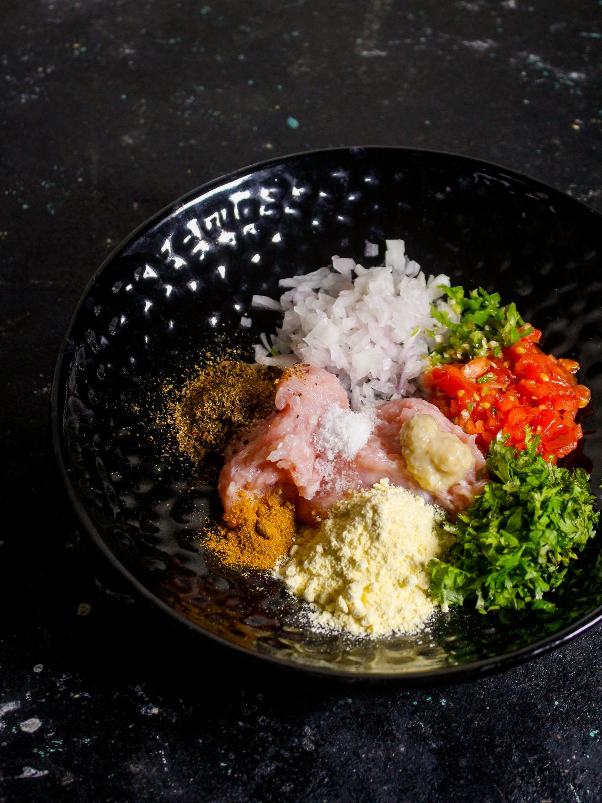 Take minced chicken, chopped vegetables and powdered spices on a plate 