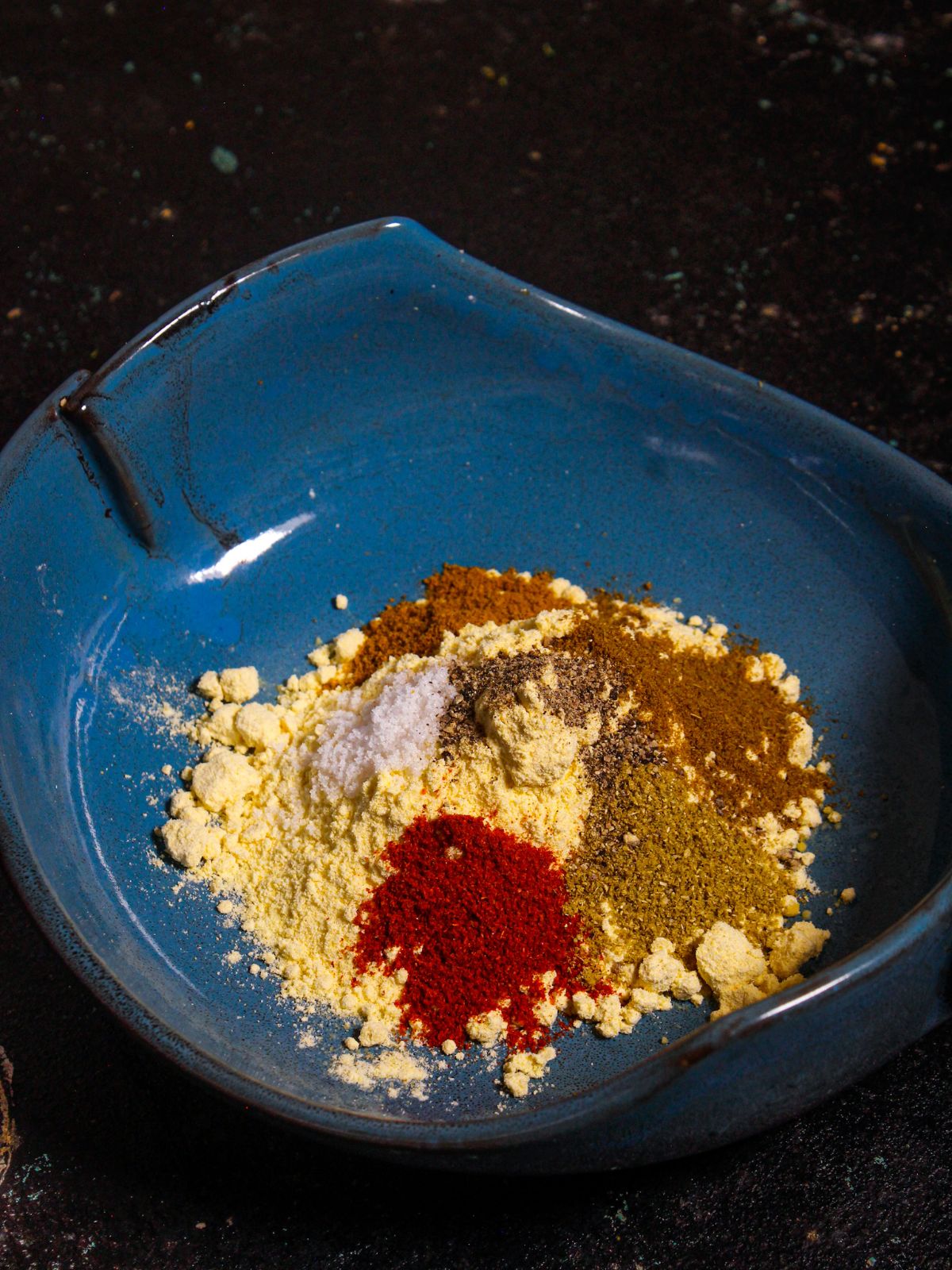 Take besan and other powdered spices in a plate and mix well to get a paste 