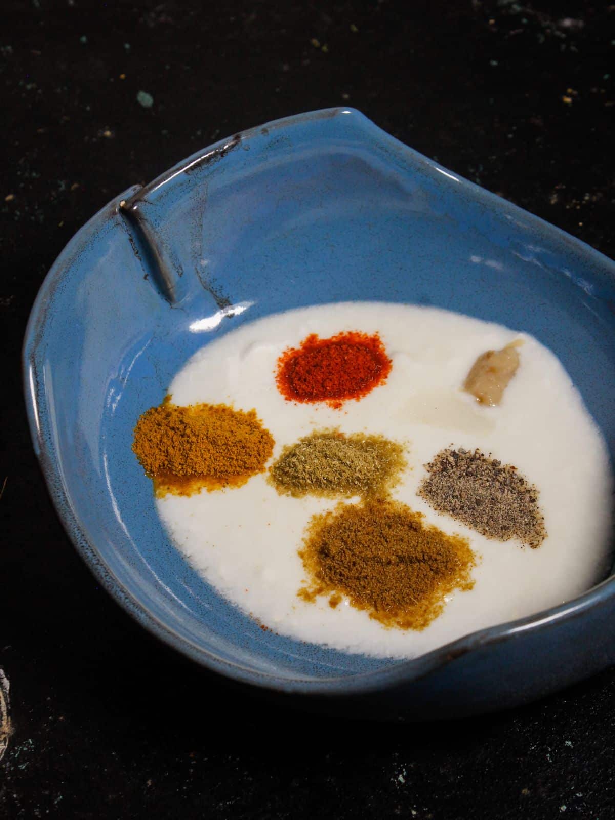 Take curd and powdered spices in a bowl 