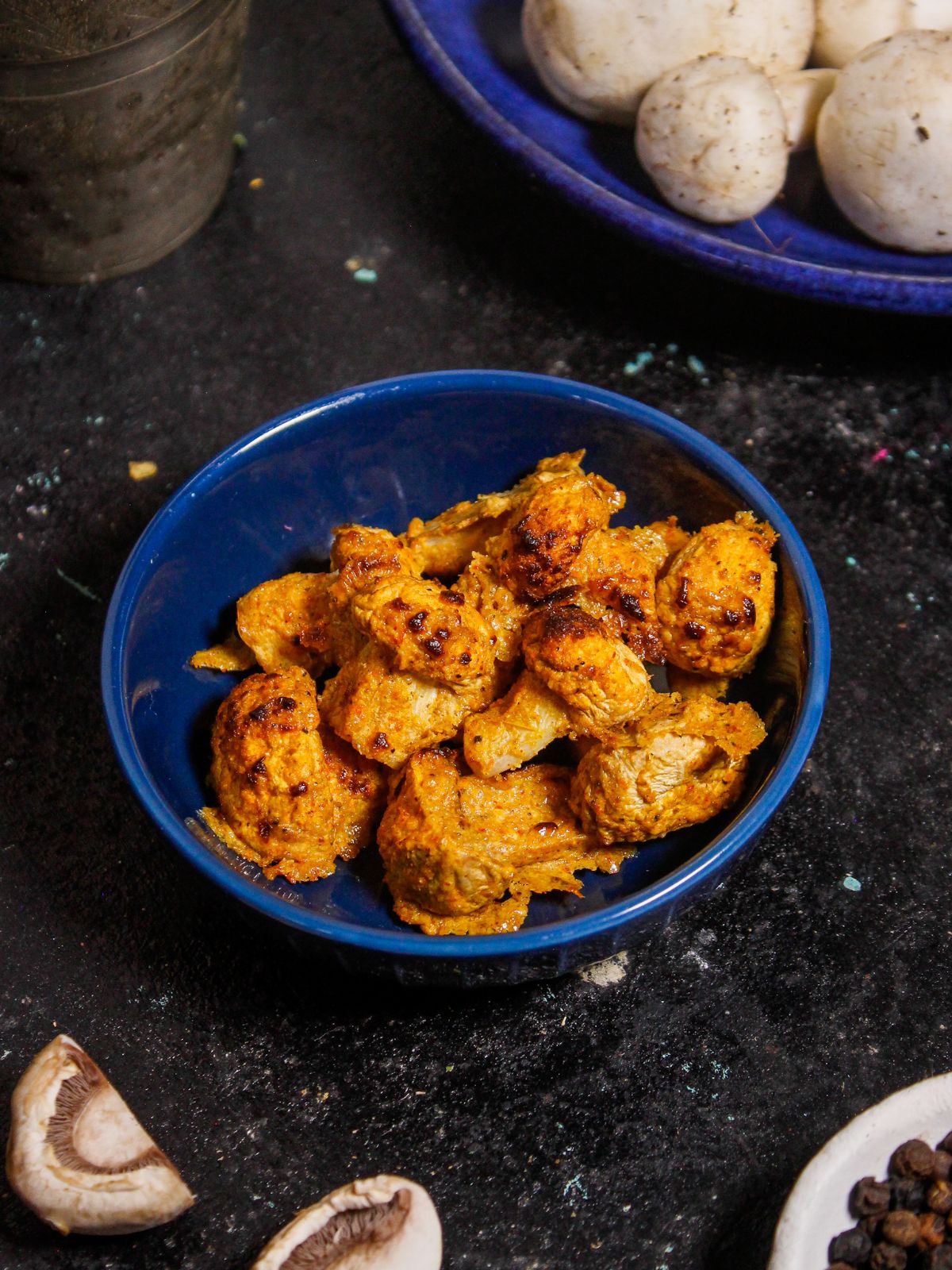 Yummy and crispy Air Fried Tandoori Mushrooms with Green Chutney served on a blue bowl 