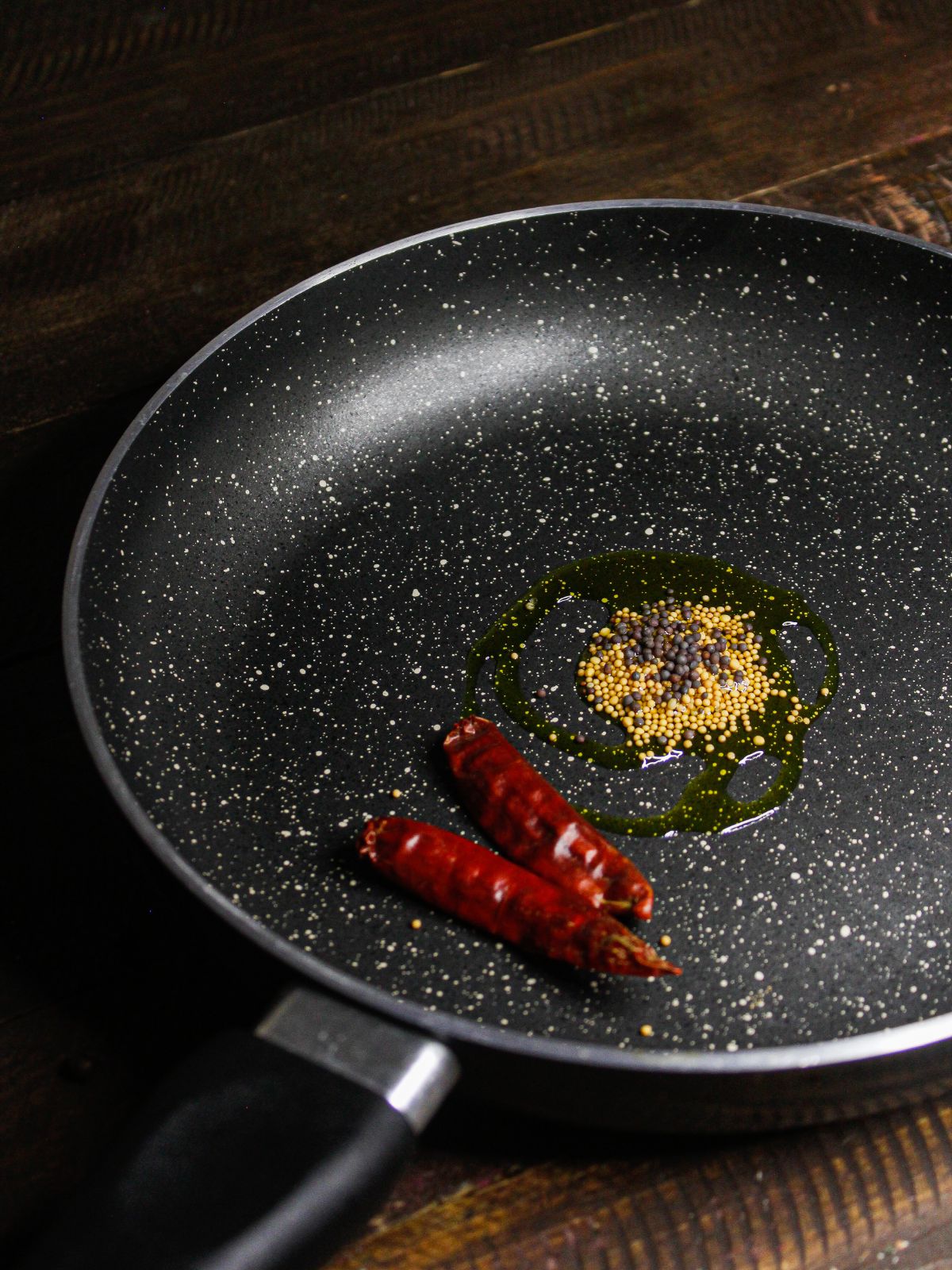 Add oil, black and yellow mustard seeds and red chilies in a pan and sauté  