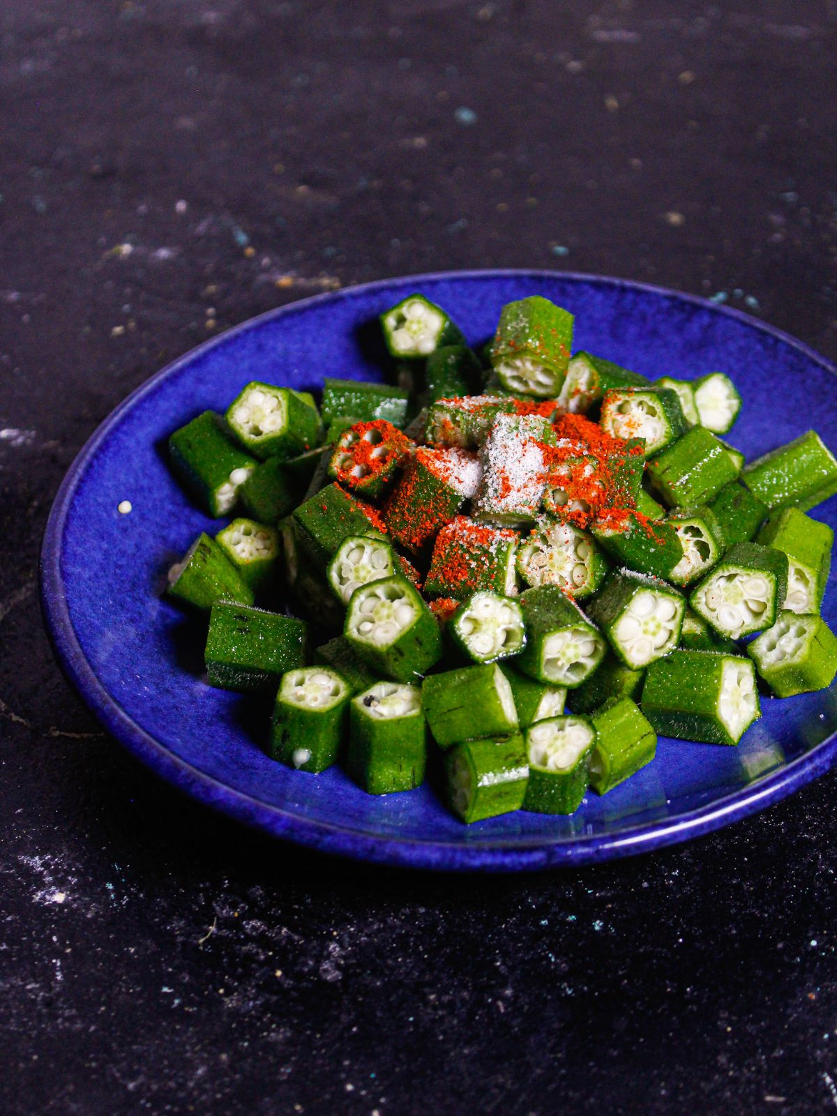 Take chopped lady fingers along with all the powdered spices on a saucer