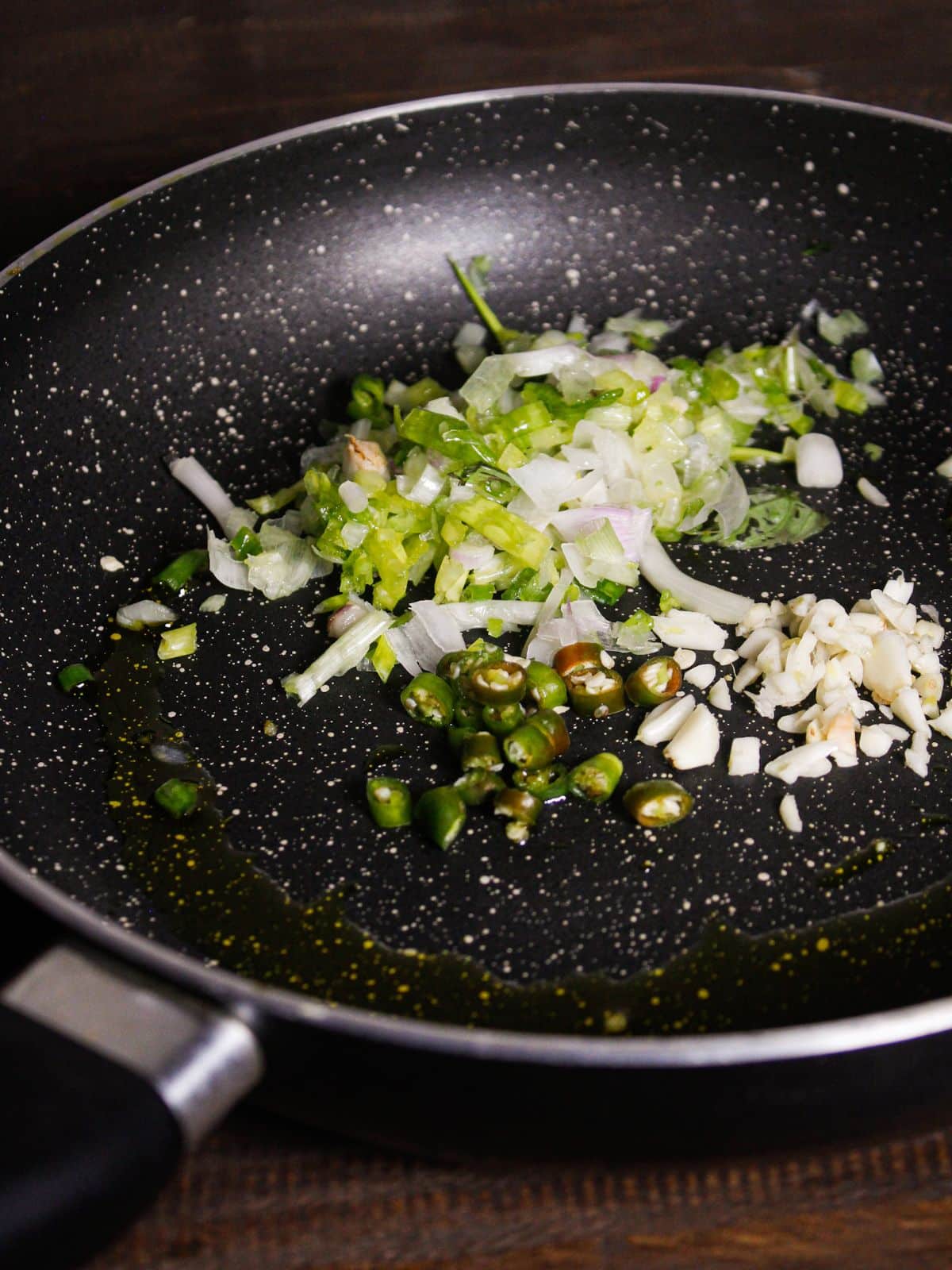 Add garlic, green chilies, spring onions & oil in a pan and Saute. 
