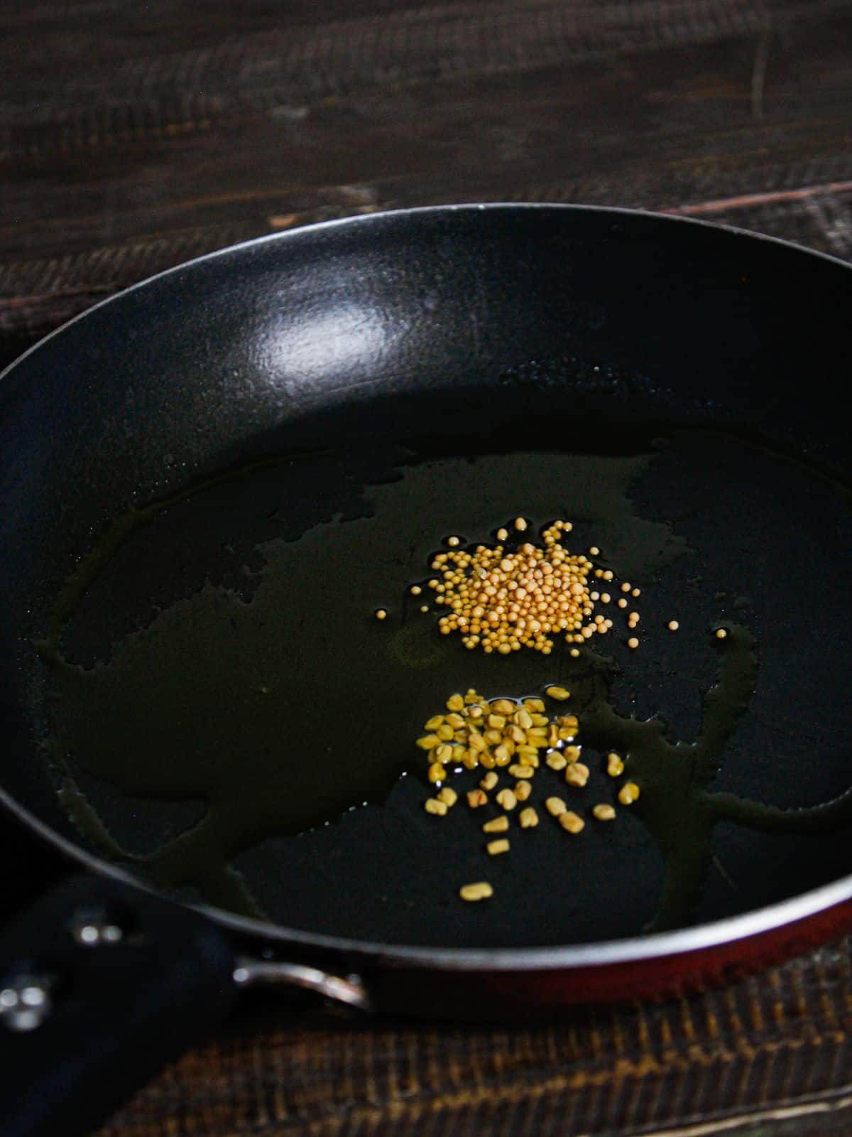 Add mustard and fenugreek seeds along with oil in a pan and saute 