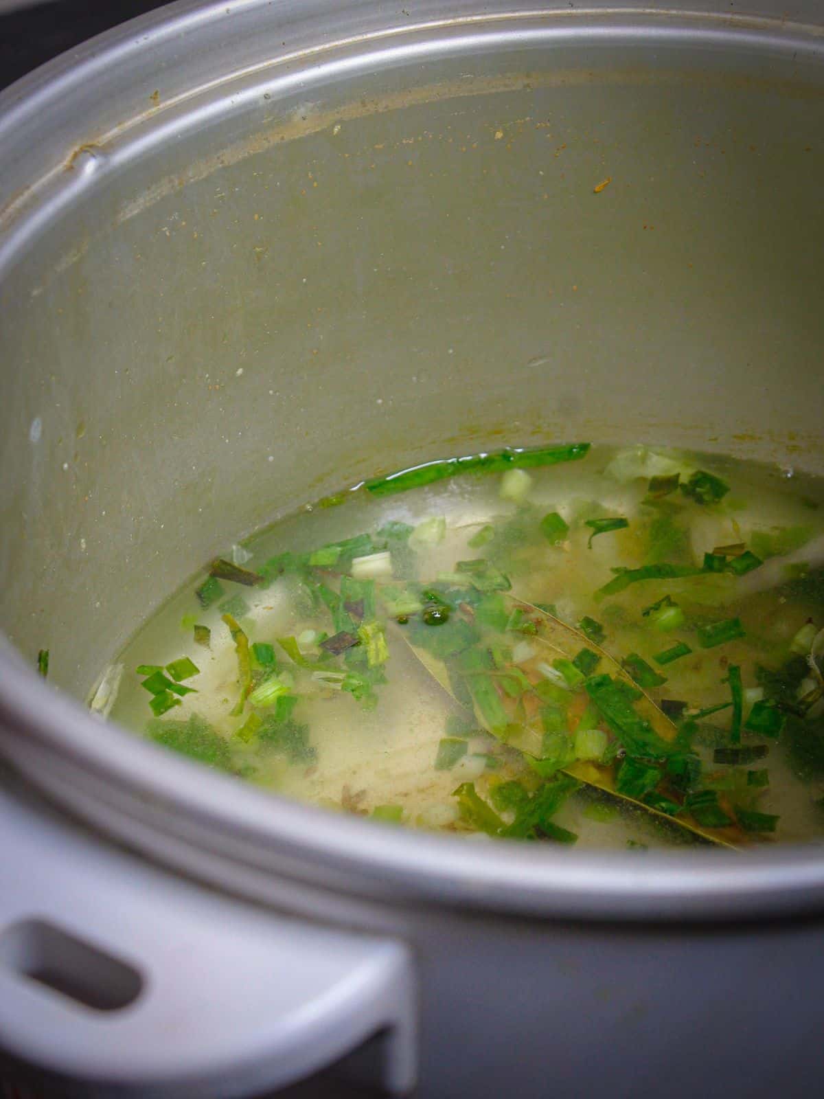 Add chicken broth to the pot and mix well