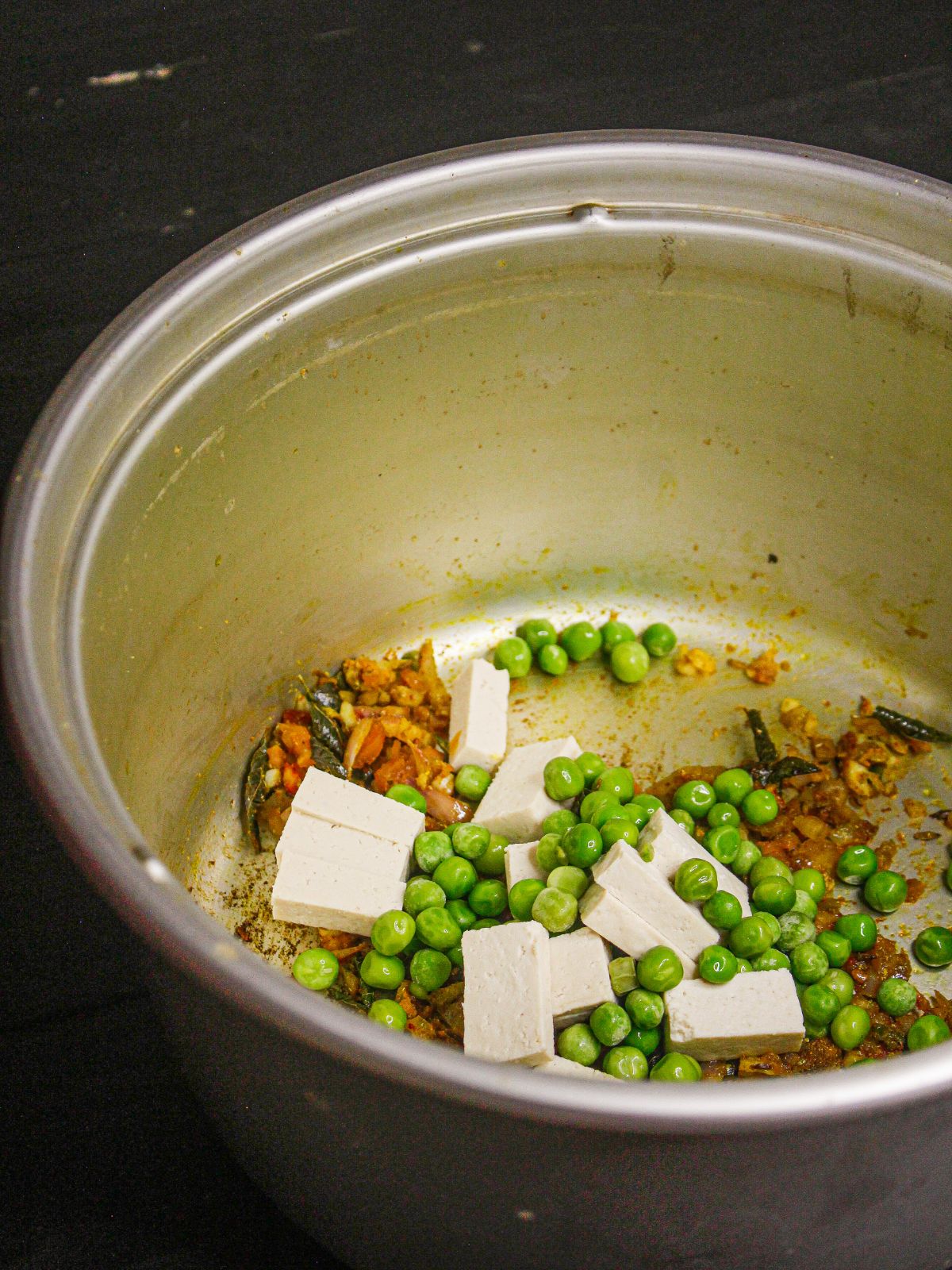 Add cubed tofu, peas and water to the pot and cook well