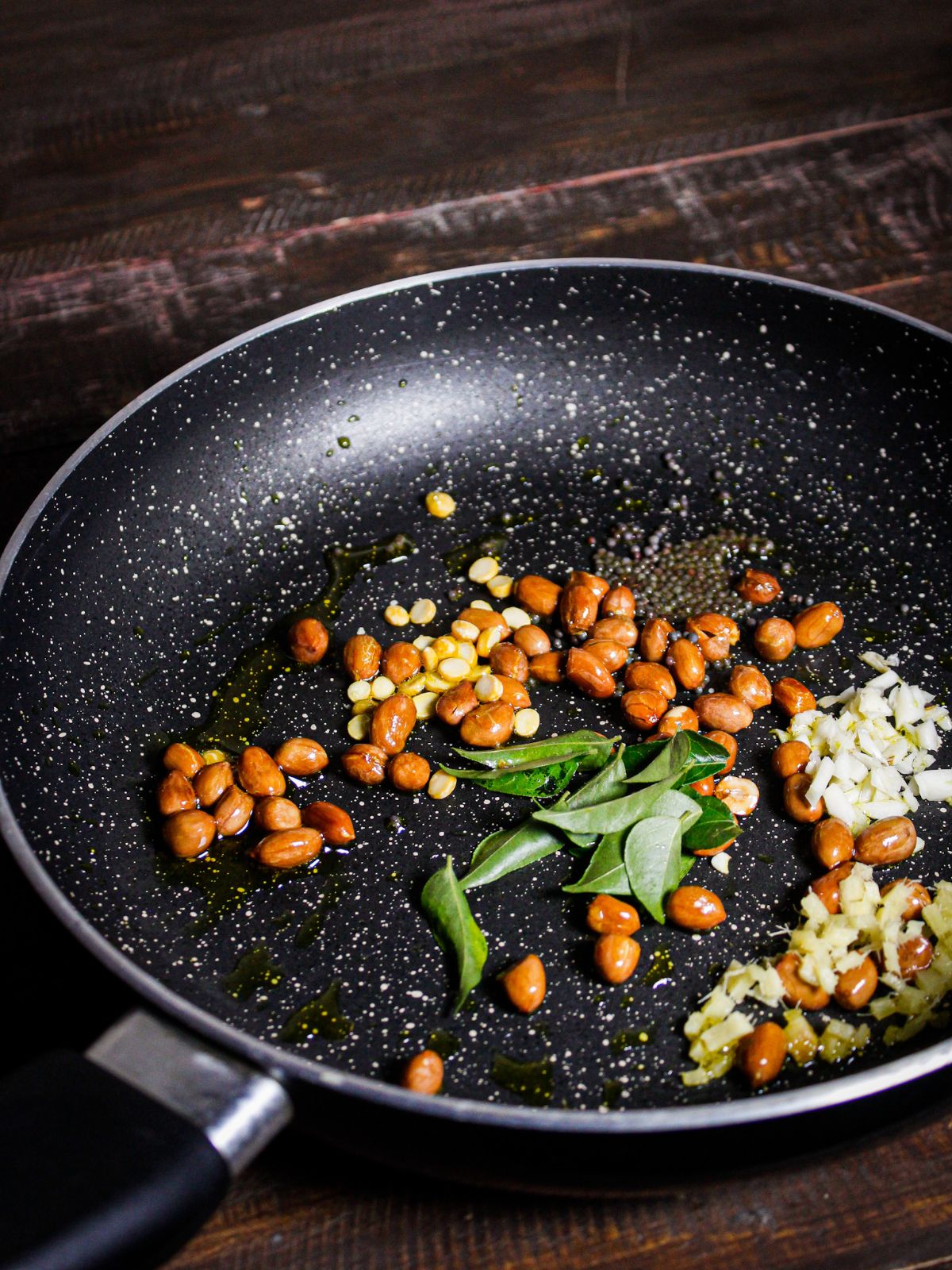 Add mustard seeds, curry leaves, chana dal, garlic, and ginger and saute 