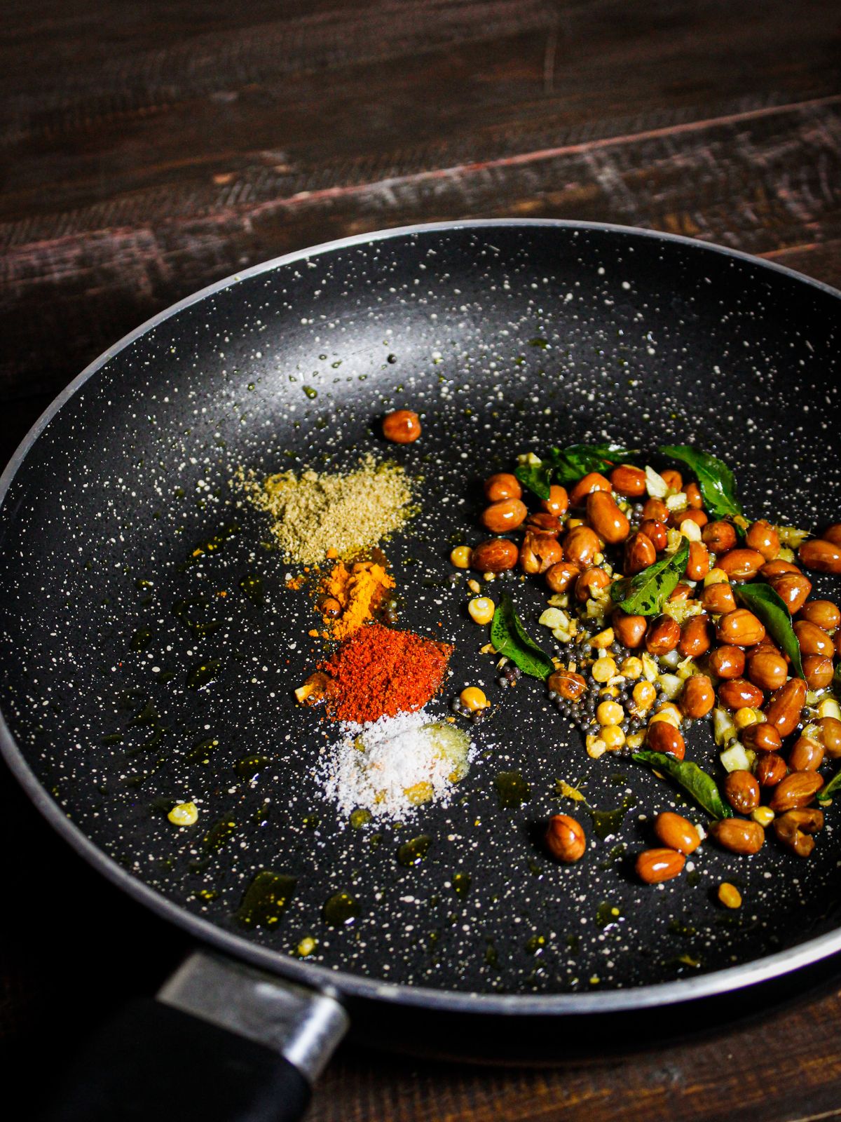 Add powdered spices to the pan and mix well