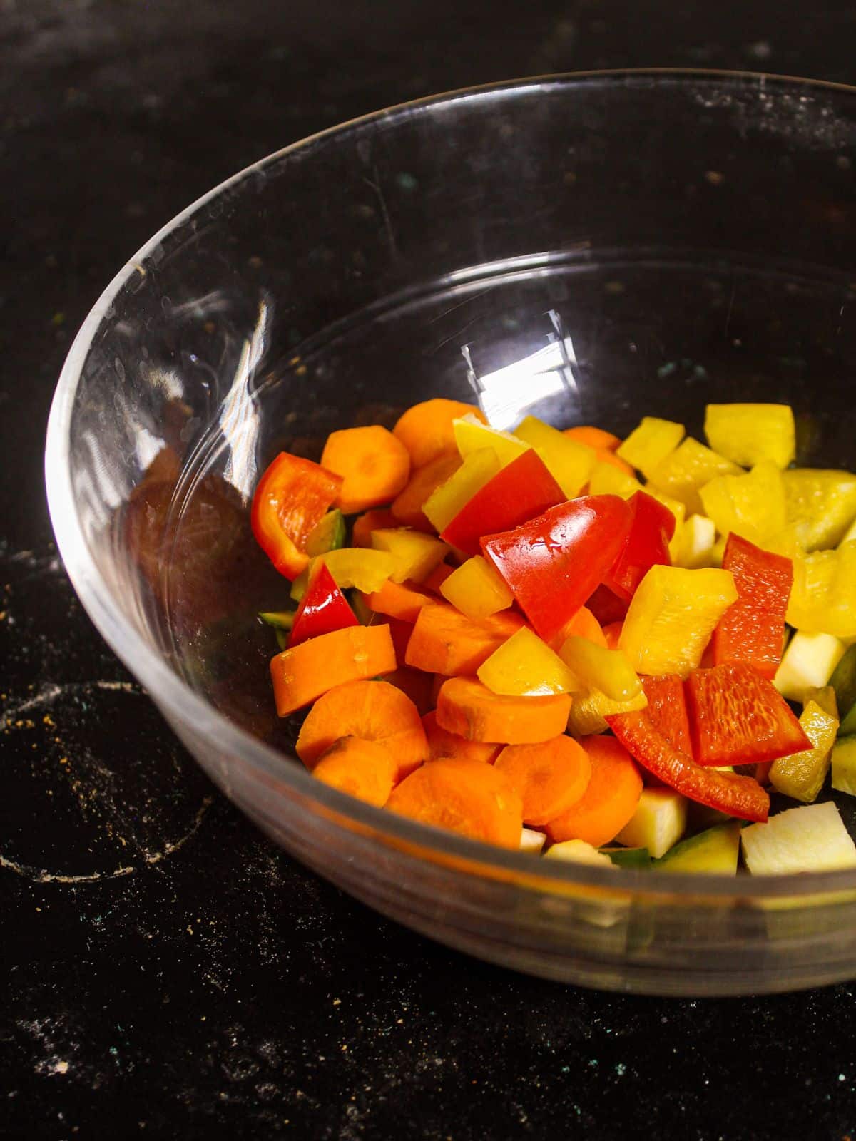 Add chopped red and yellow bell peppers into the bowl 