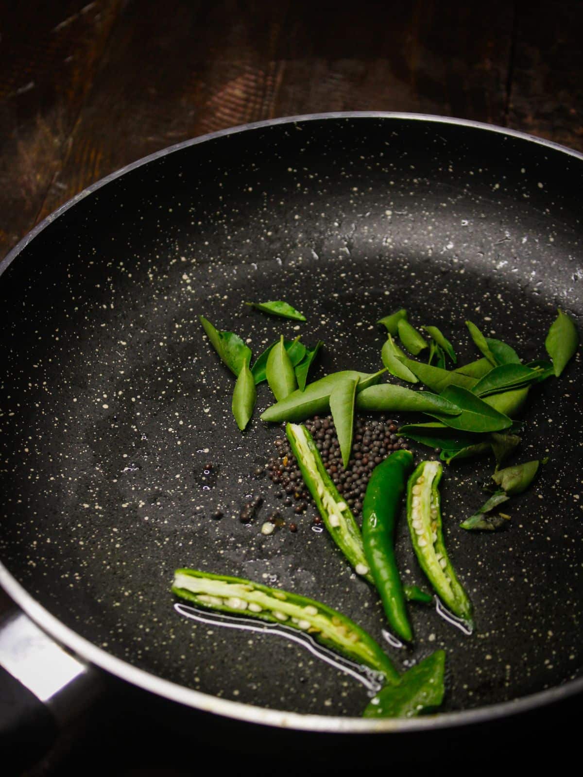 Add slit green chilies into the pan 