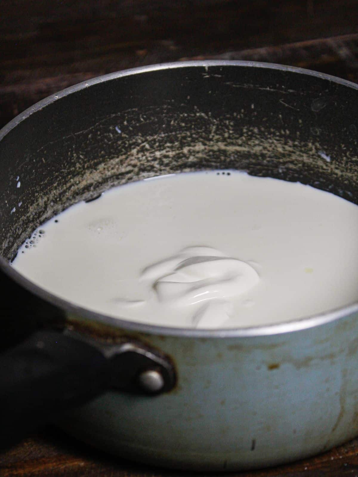 Add cream to the milk in the vessel 
