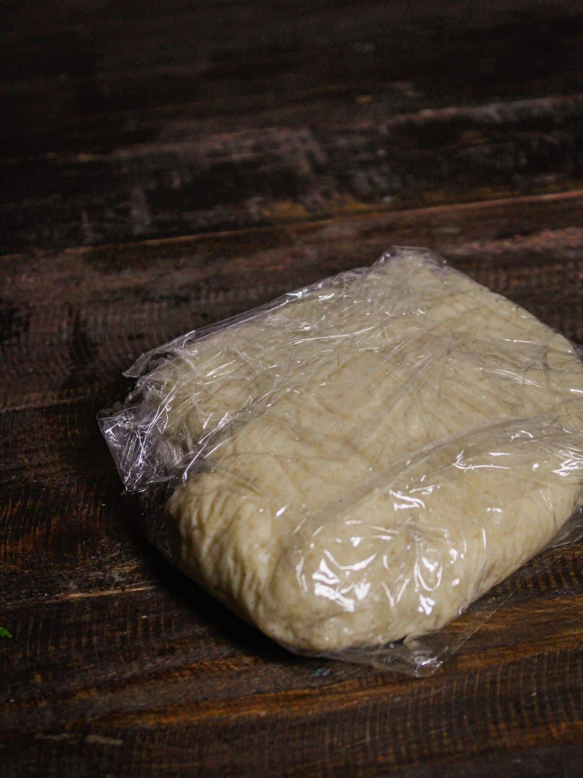 Wrap the dough into plastic and make it flat 