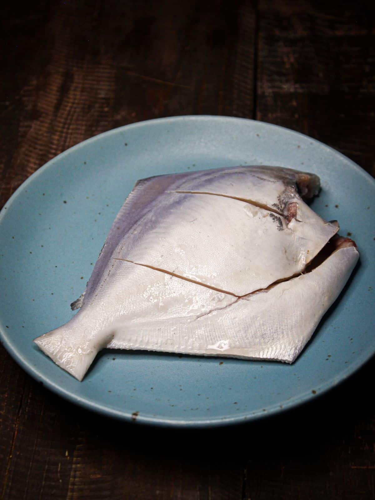 Take fish on a plate and make slits  