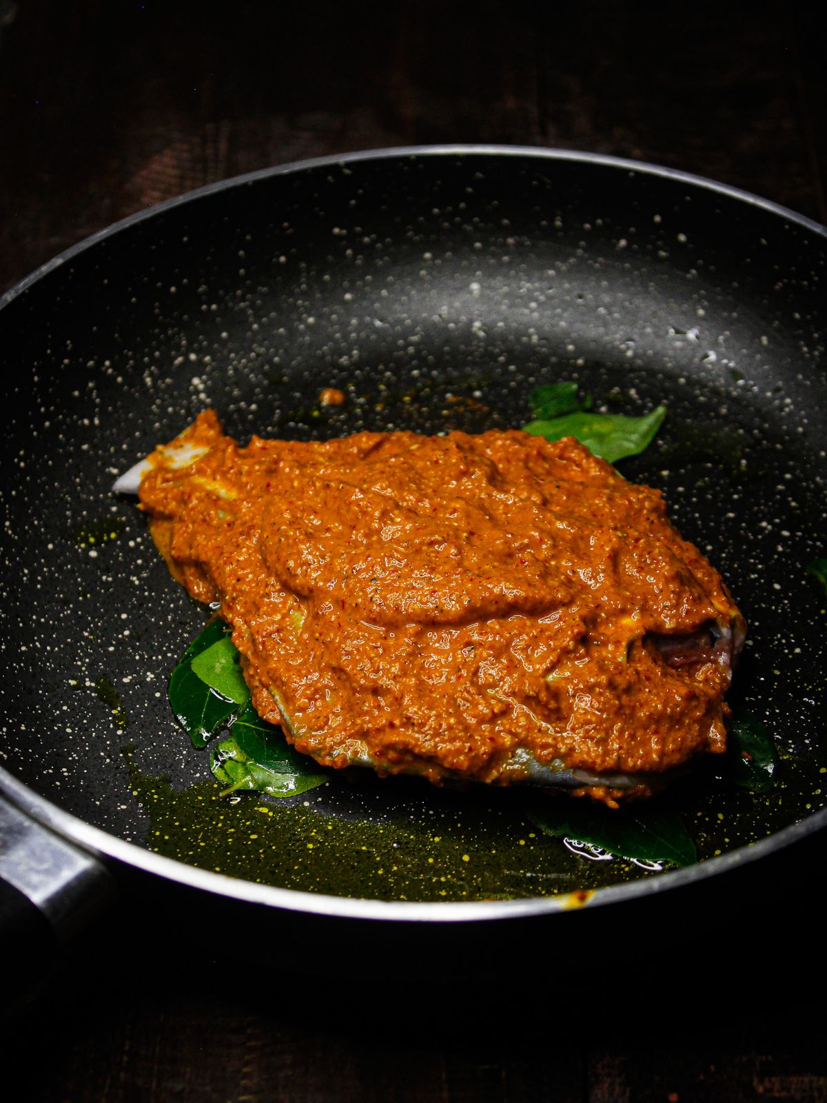 Transfer the masala coated fish into the pan and cook well 