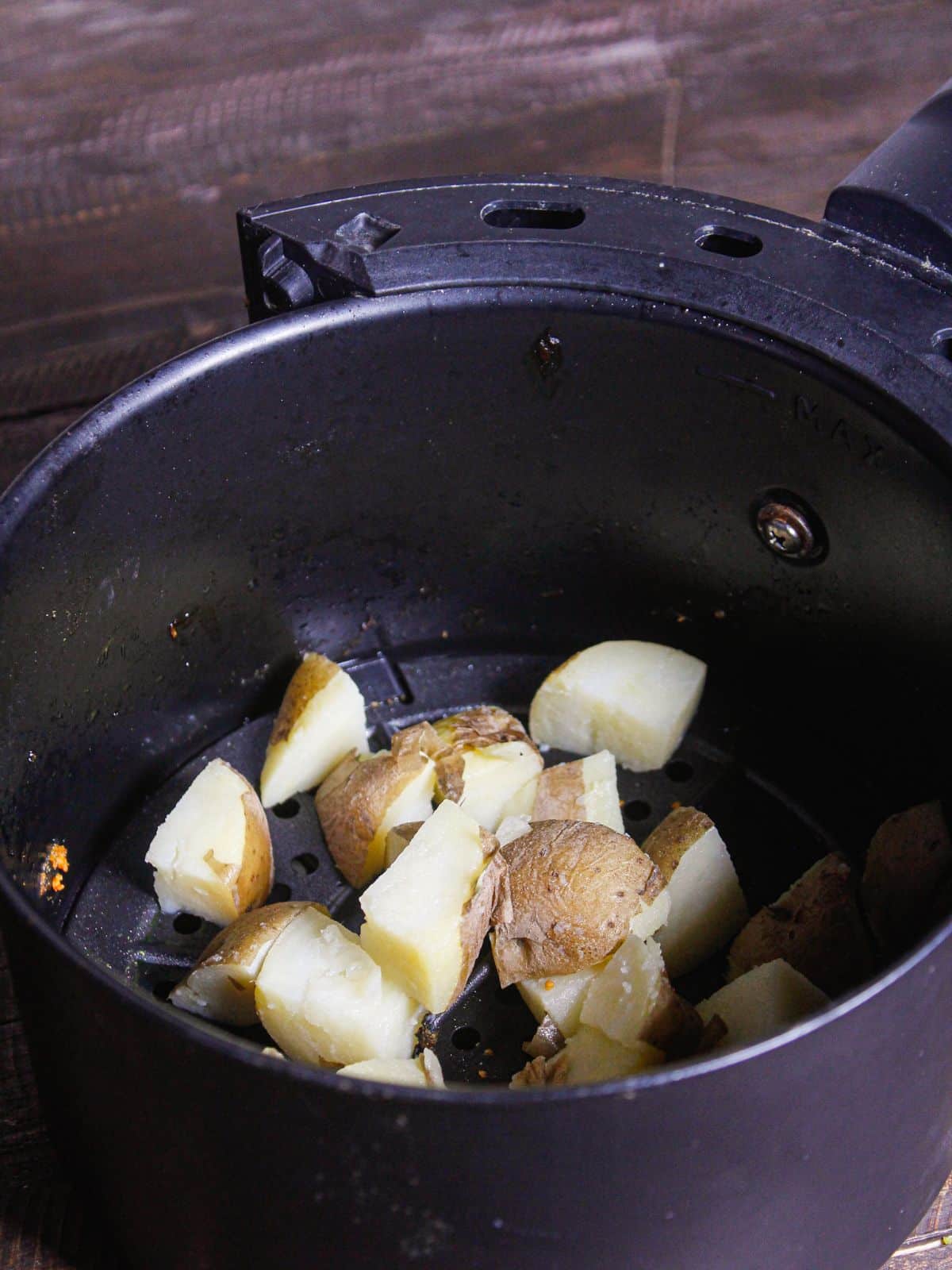 Transfer the boiled and cubbed potatoes into the air fryer 