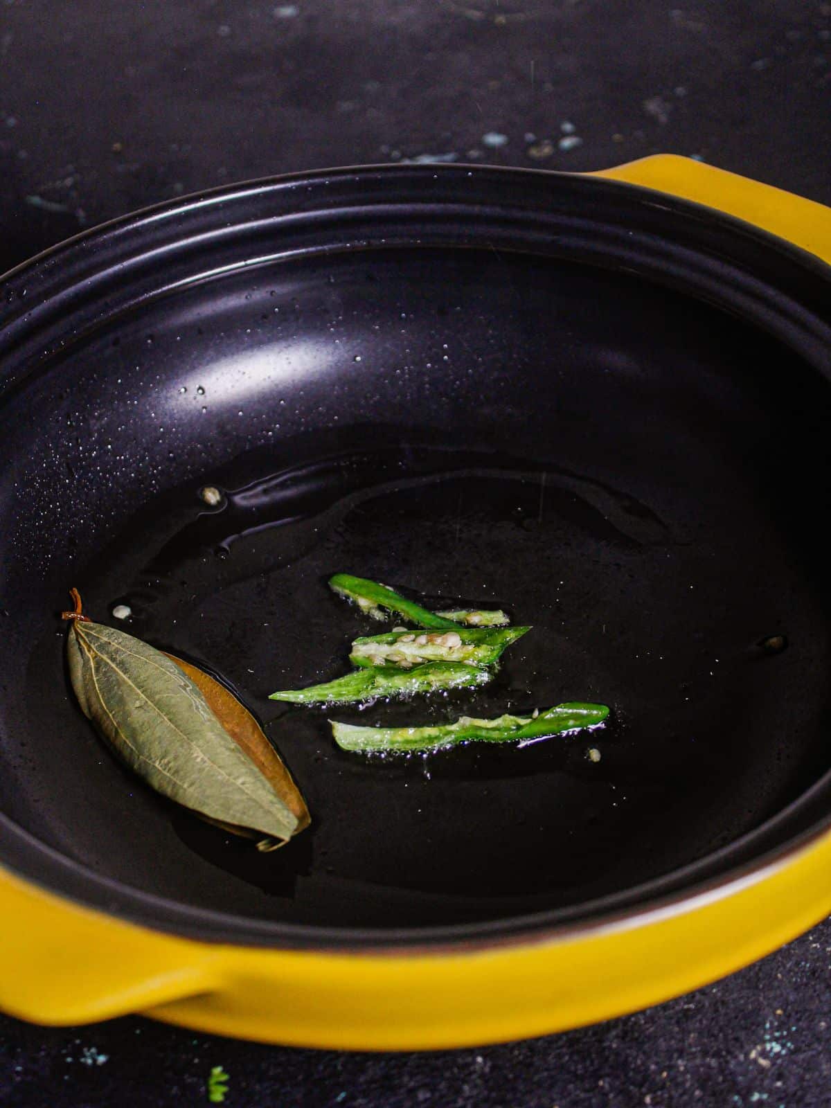 Add slit green chilies to the pan 