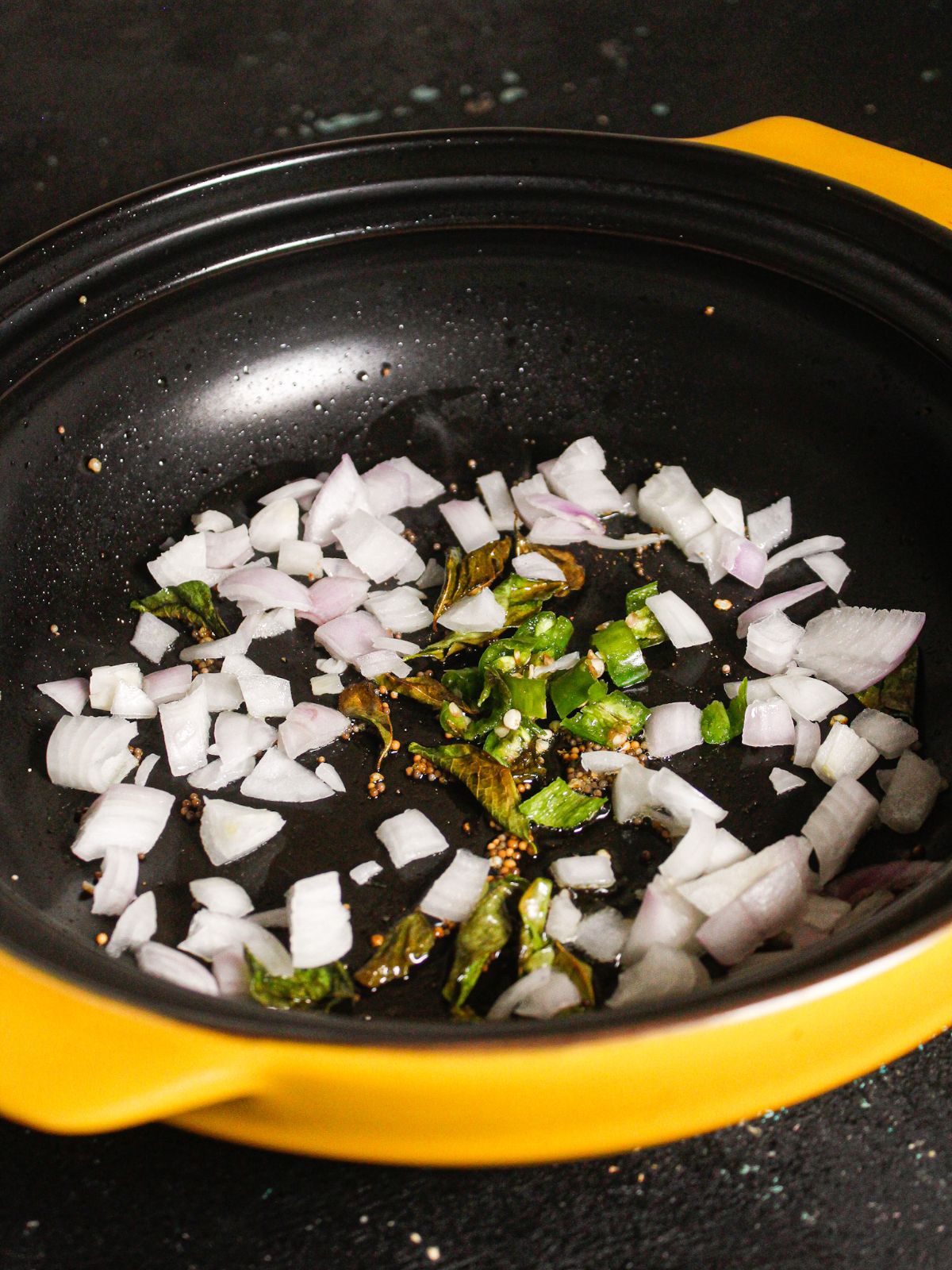 Add chopped onions and chillies to the pan and saute 