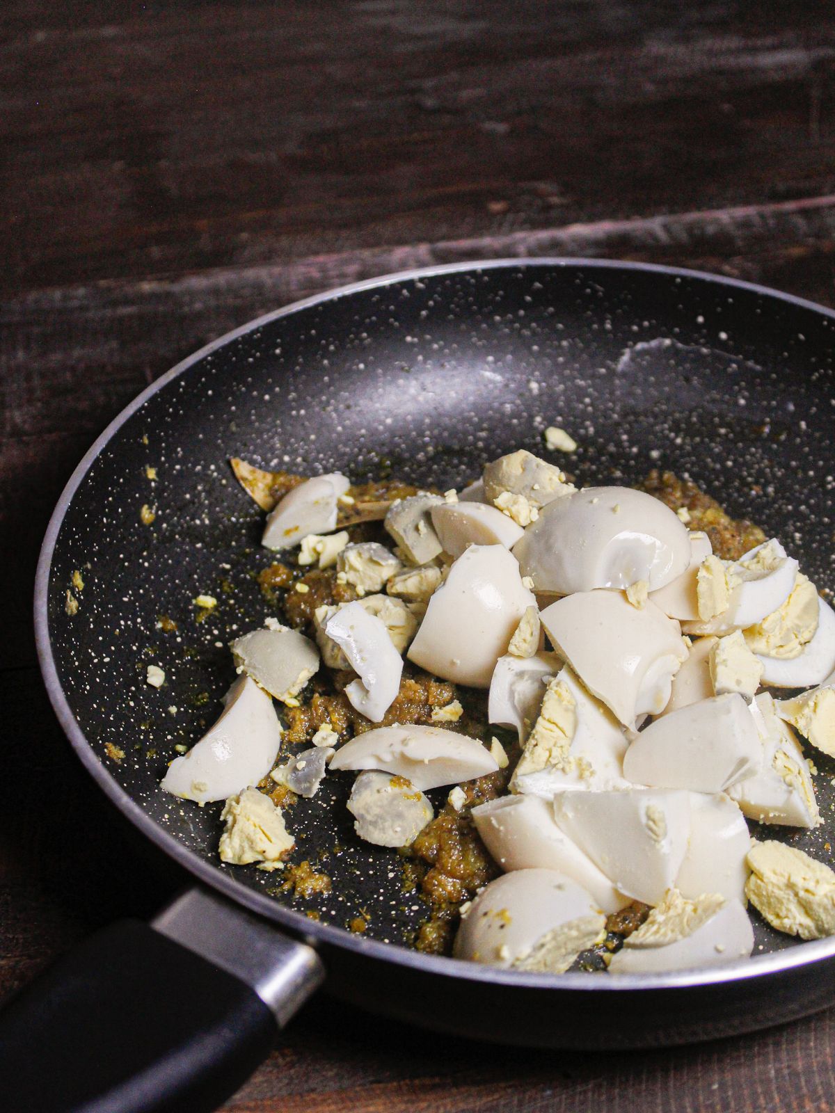 Add pieces of boiled eggs to the pan and mix well 