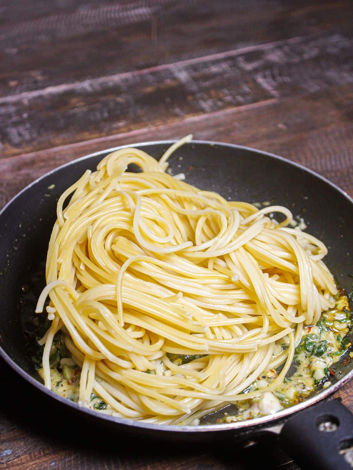 Add boiled spaghetti to the pan and mix well 