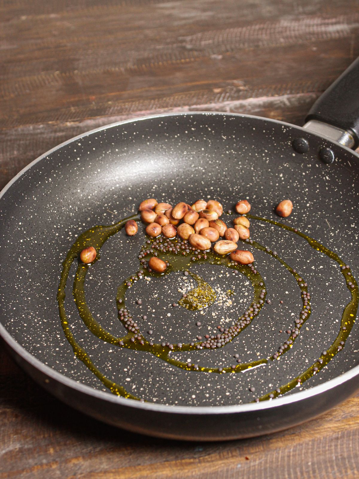 Add peanuts, mustard seeds and oil into the pan and saute 