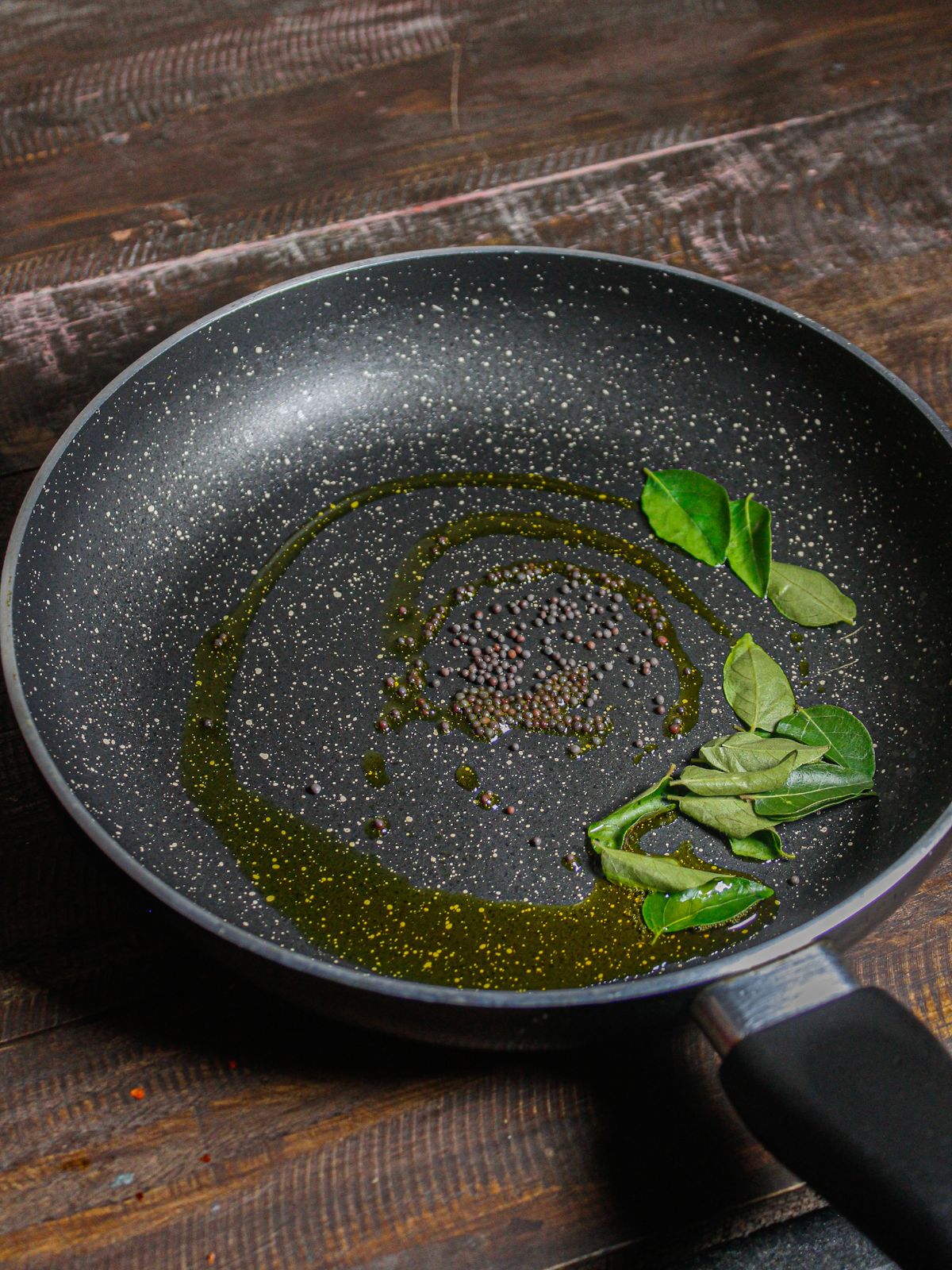 Mustard seeds and curry leaves in a pan 