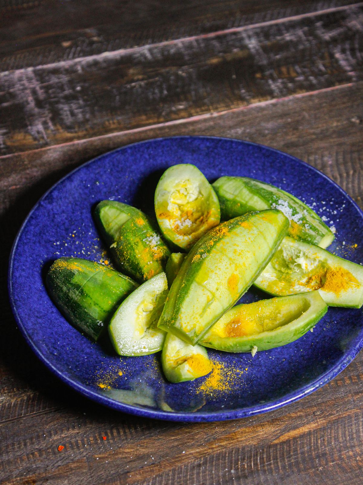 Take gourds pieces on a plate and add powdered spices over it 