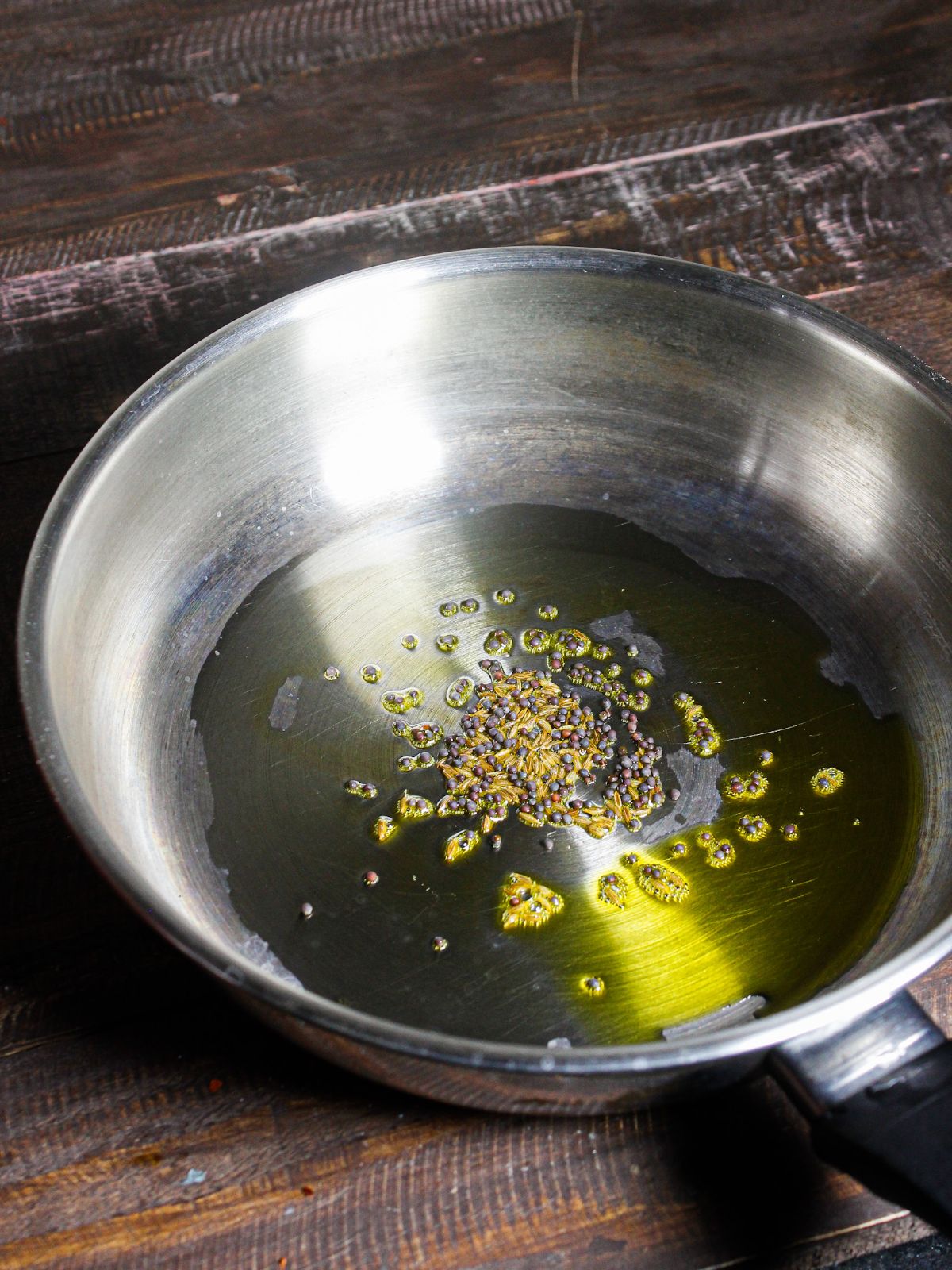 Take cumin and mustard seeds with oil in a pan 