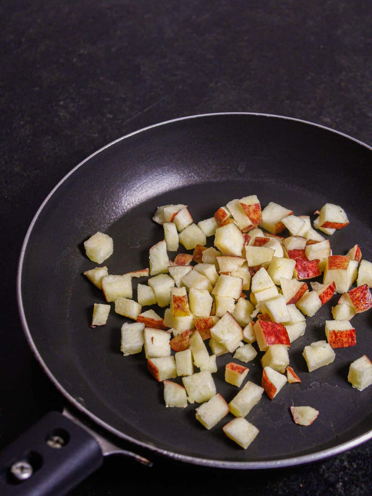 Take apple cubes in a pan with oil 