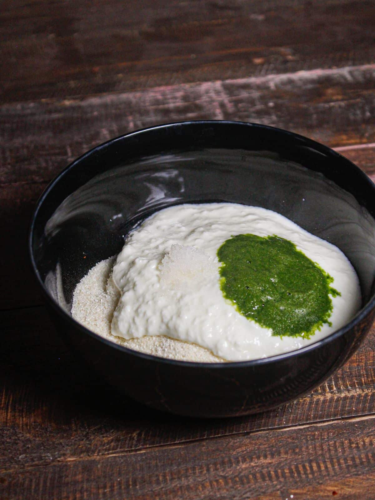 Take semolina, green chillies coriander paste and curd in a bowl 