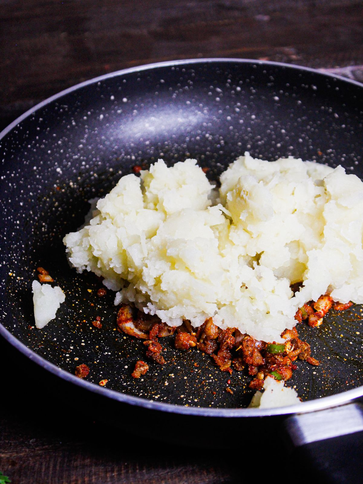 Add mashed potatoes to the pan and mix well