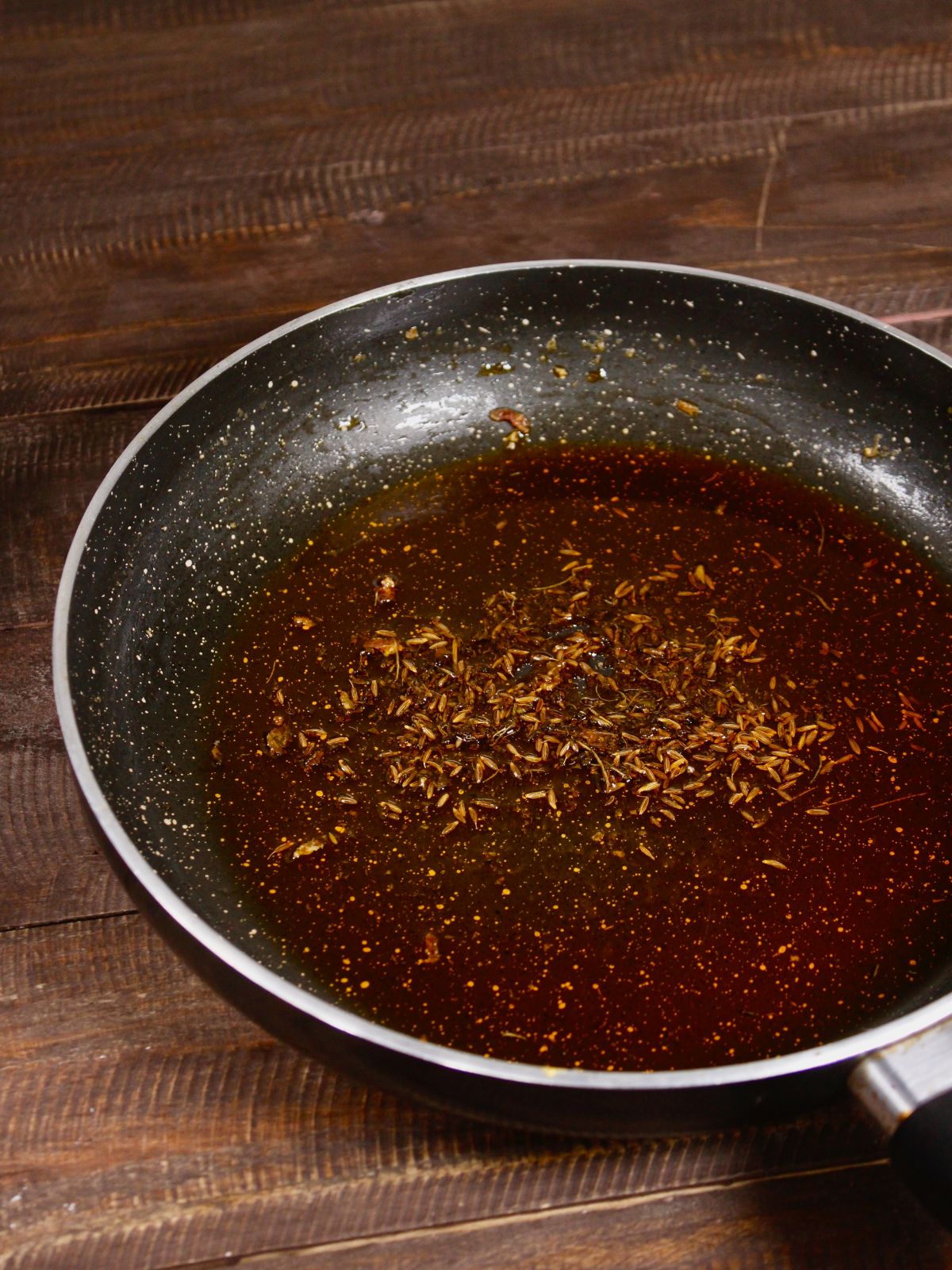 cumin seeds with oil in a pan 