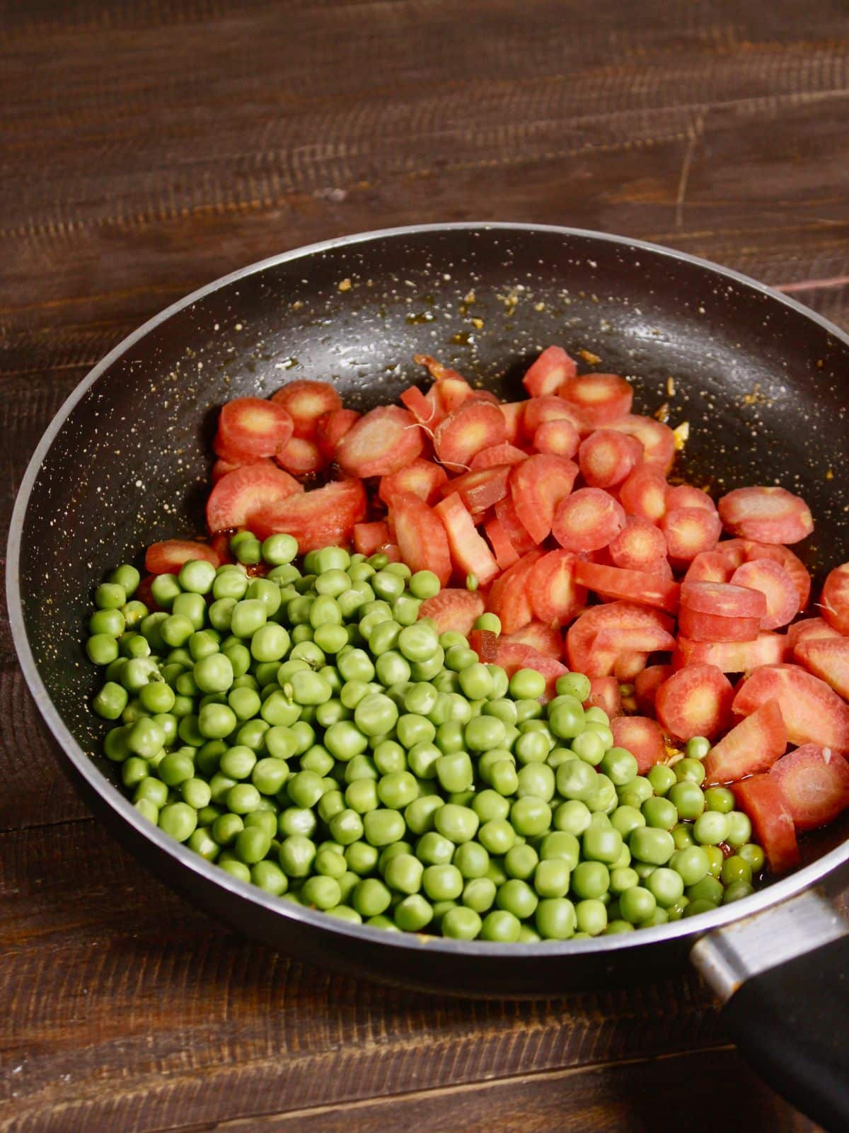 add chopped carrots and peas to the pan 
