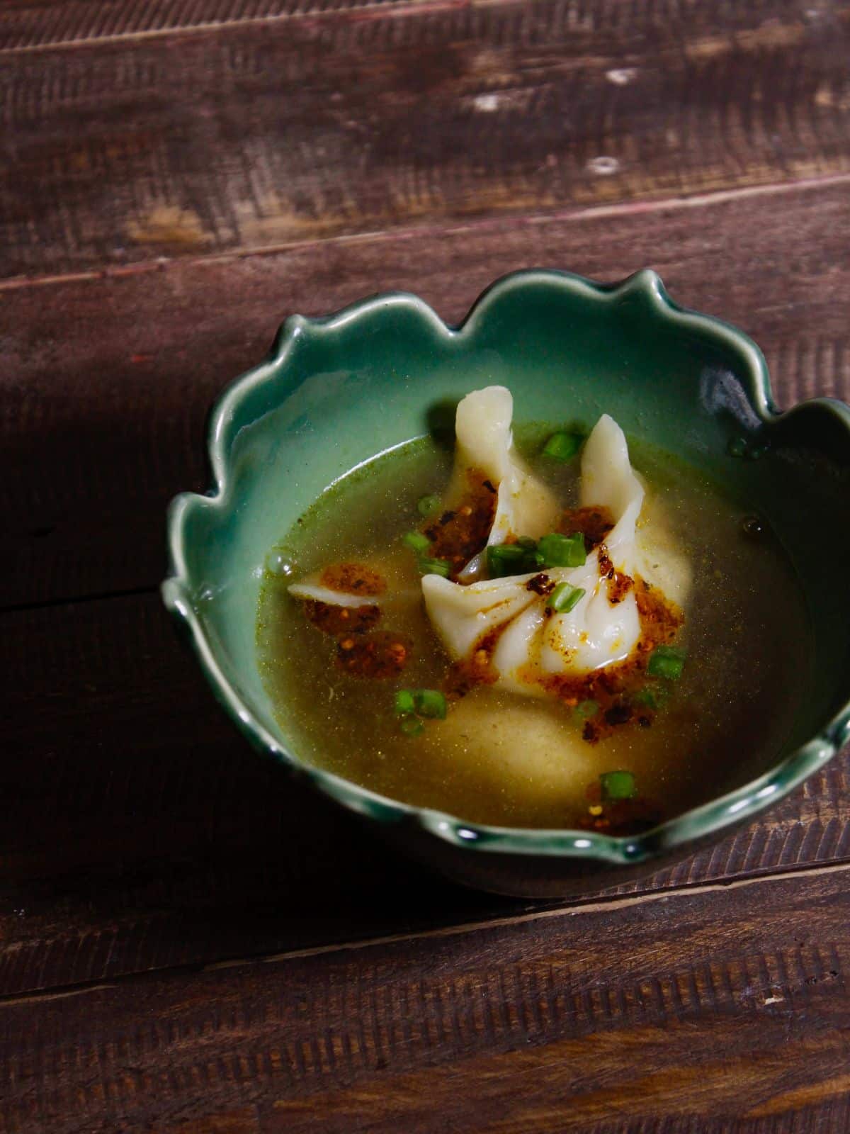 garnish dumplings with warm broth with chilli and coriander leaves and enjoy 