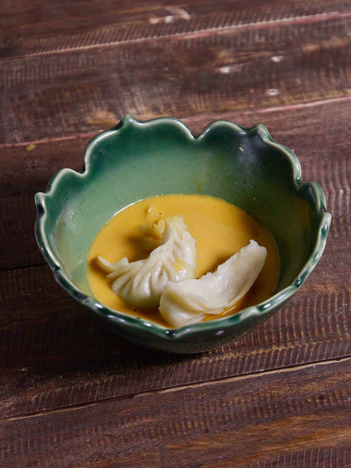 take dumplings in a bowl and add some peanut sauce over it 